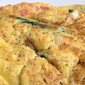 Egg omelet or scrambled egg with cheese tomatoes and dark-Green vegetables fat added in cooking - nutritional values, calories